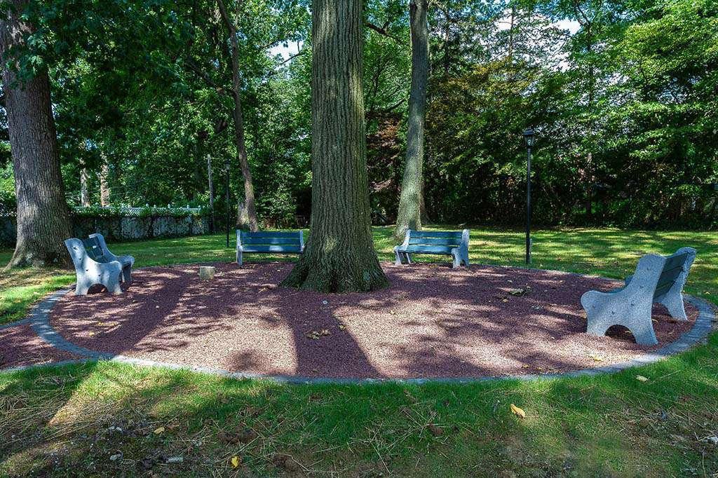 Outdoor bench seating area surrounding a tree at Eola Park apartments for rent in Philadelphia, PA
